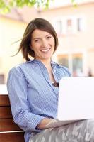 Young woman in the park with laptop photo