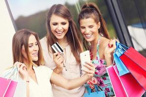 Group of girlfriends shopping in the city with credit card photo