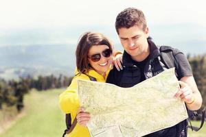 Young couple with map in mountains photo