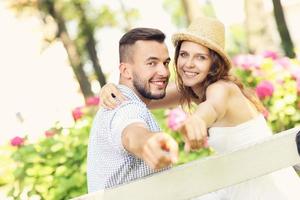 pareja en el parque apuntando a la cámara foto