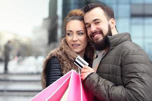 Young couple shopping in the city with credit card photo