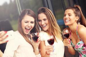 Group of friends with wine taking selfie photo