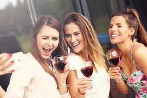 grupo de amigos con vino tomando selfie foto