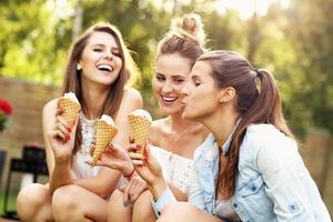 Happy group of friends eating ice-cream outdoors photo