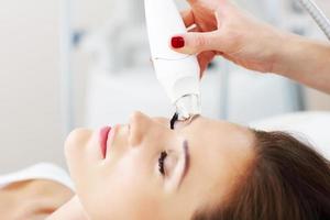 mujer con tratamiento facial en salón de belleza foto