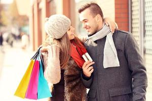 Young couple with credit card shopping in the city photo