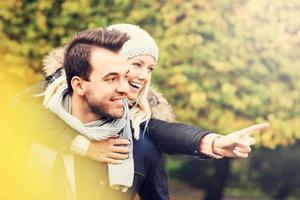 joven pareja romántica señalando en el parque en otoño foto