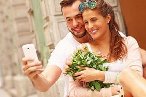 joven pareja romántica con smartphone en la ciudad foto