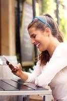 Happy woman using smartphone in cafe photo