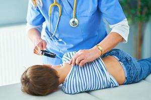 Pediatrician doctor examining little kids in clinic ears check photo