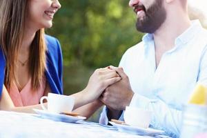 manos de pareja romántica en café foto