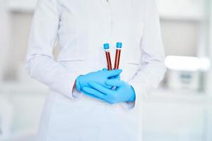 Woman holding test tube with blood and mixing machine photo