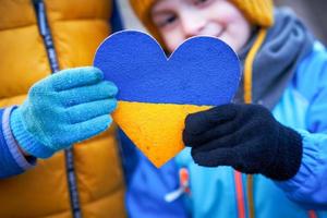 Picture of a child with a lot of love and peaceful message holding heart photo