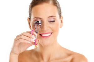 Portrait of a sensual woman with eyelash curler photo