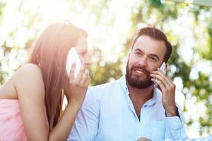 pareja romántica usando teléfonos inteligentes en el café foto