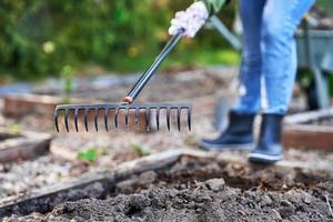 joven mujer feliz con herramientas de jardín trabajando foto