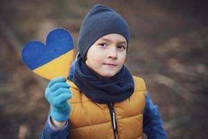 Picture of a child with a lot of love and peaceful message holding heart photo