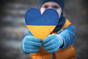 Picture of a child with a lot of love and peaceful message holding heart photo