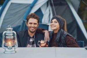 Young nice couple having fun on camping with kerosene lamp photo