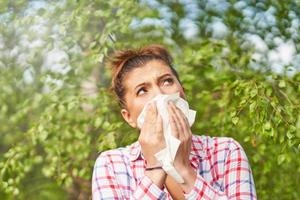 Young woman having allergic symptoms with tissue photo