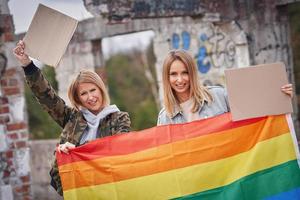 pareja lgbt con tablero de mensajes en blanco y bandera foto