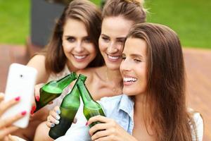 Happy group of friends drinking beer outdoors photo