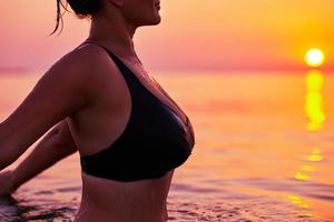 Young woman swimming in the sea on sunrise photo