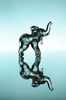 Glass elephant over blue background photo