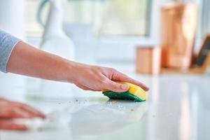 mujer joven limpiando la suciedad en la cocina foto