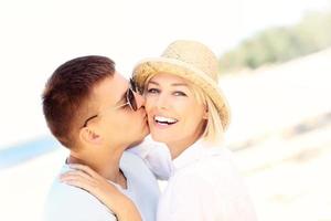 Man kissing a woman at the beach photo