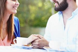 manos de pareja romántica en café foto