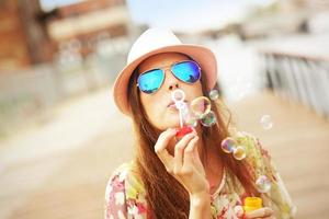 Happy woman blowing soap bubbles photo