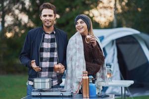 Young nice couple having fun on camping while cooking and eating photo