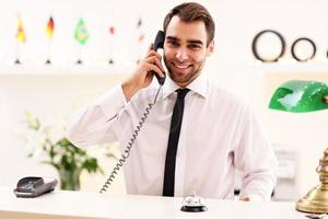 Happy receptionist working in hotel photo