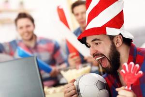 Happy male friends cheering and watching sports on tv photo