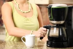 Woman making coffee with coffee maker photo