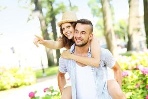 Couple in the park pointing to the camera photo