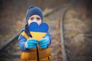 Picture of a child with a lot of love and peaceful message holding heart photo