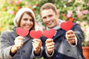 Happy couple posing with hearts photo