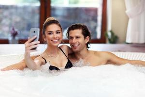 Happy couple enjoying jacuzzi in hotel spa photo