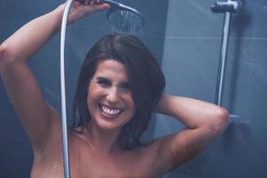 Adult woman under the shower in bathroom photo