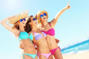 Group of women pointing at something on the beach photo