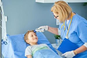 Adult woman and young patient in hospital bed photo