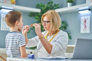 Pediatrician doctor examining little kids in clinic photo