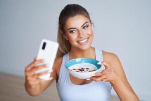 retrato de una hermosa mujer hispana comiendo yogur promoviendo un estilo de vida saludable foto