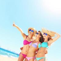 Group of women pointing at something on the beach photo