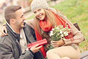 pareja romántica con regalos en el parque foto