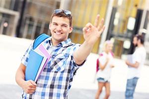 Handsome student showing ok sign in the campus photo