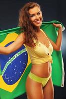 Happy Brazilian fan cheering with flag photo