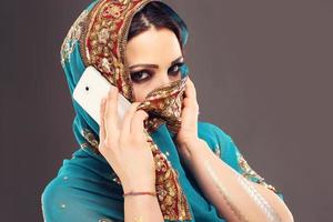 mujer árabe hablando por teléfono inteligente foto